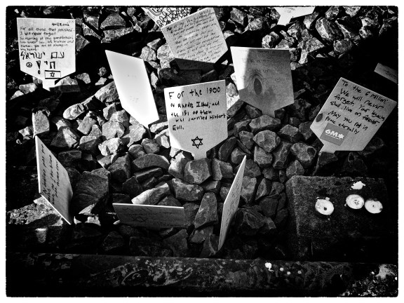 Handwritten signs left on the railway track to Auschwitz. (Middle sign and Photograph by Noah Botman, April 2013)